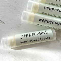 Lip balm tubes with peppermint text, light green and white, clear cap, shea butter label