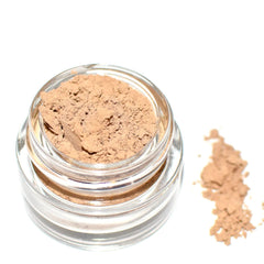 Close-up of fingers applying shimmering taupe eye shadow with a blending brush for a smoky effect