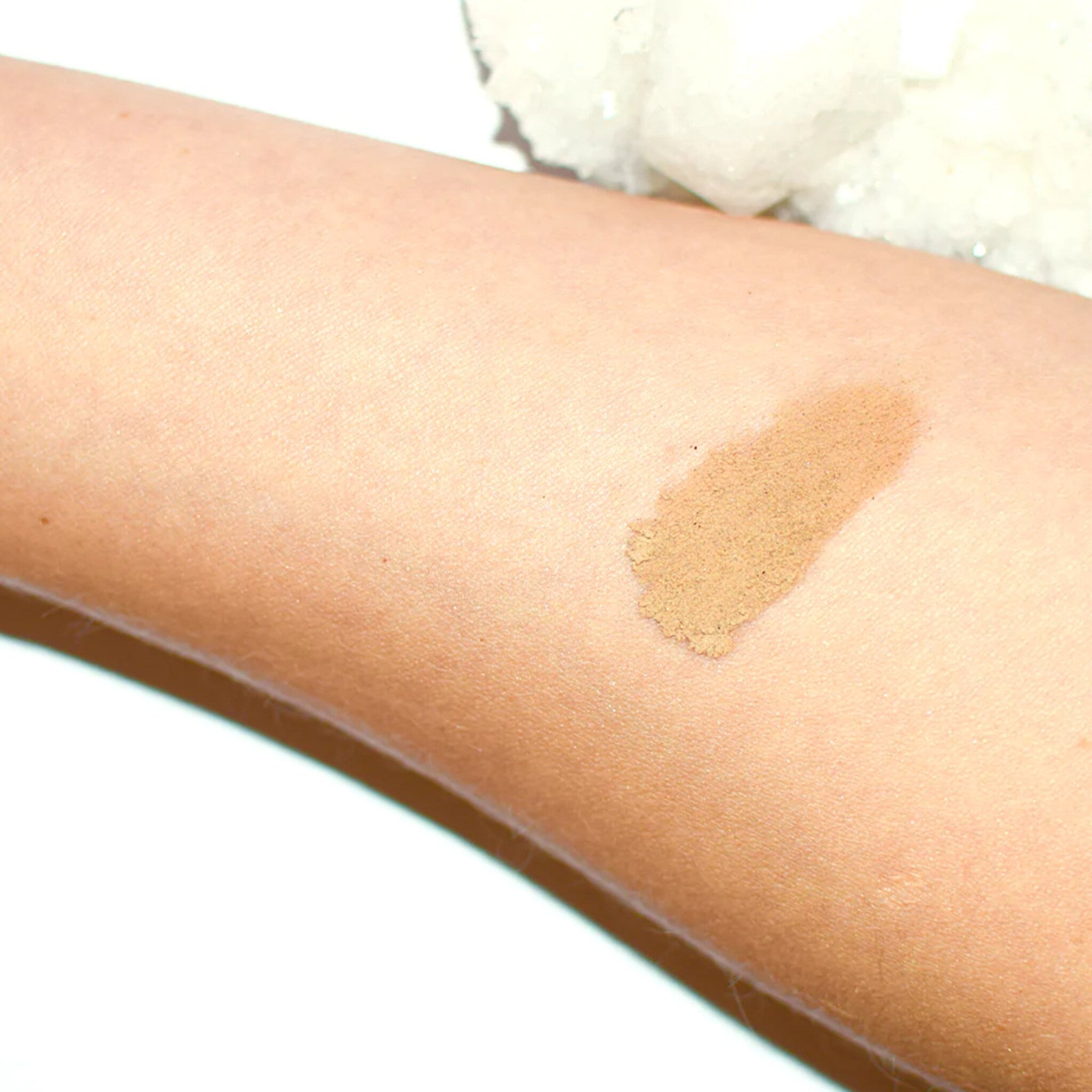 Side view of cave-inspired eye shadow palette showing textured earthy tones and rugged packaging design