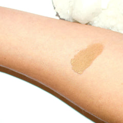 Side view of cave-inspired eye shadow palette showing textured earthy tones and rugged packaging design