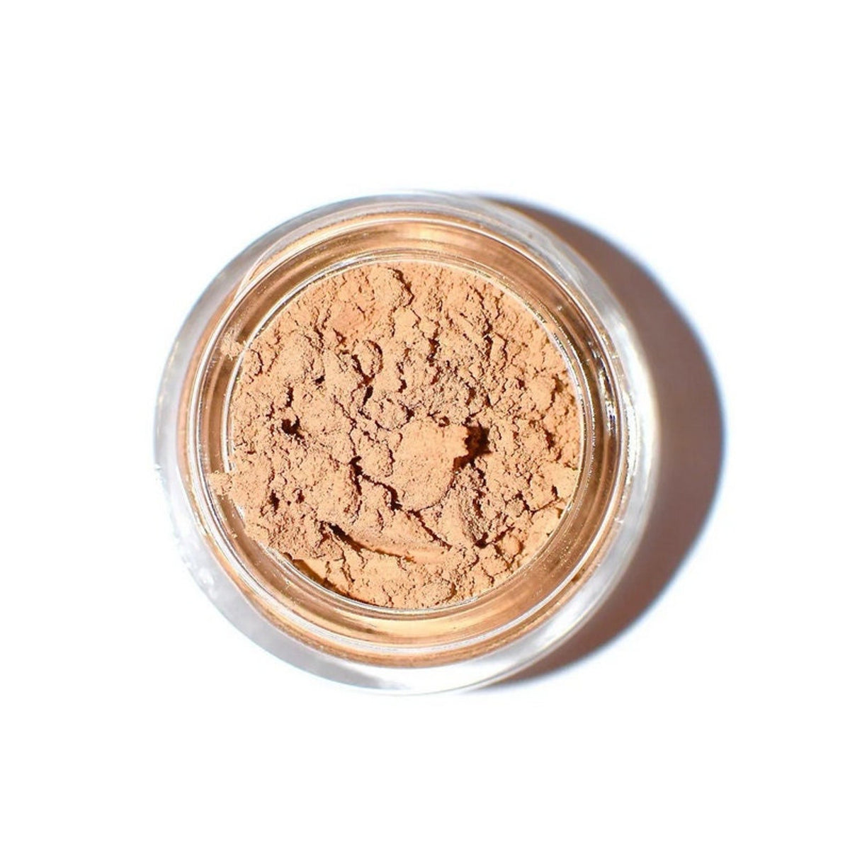 Close-up of cave-inspired eye shadow palette with earthy bronze and taupe shades in sleek black compact