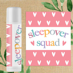 Lip balm with pink and white heart pattern, "Sleepover" text, and white tube design