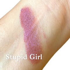 Lipstick swatch of pink and mauve metallic color on skin, with "Stupid Girl" text visible.