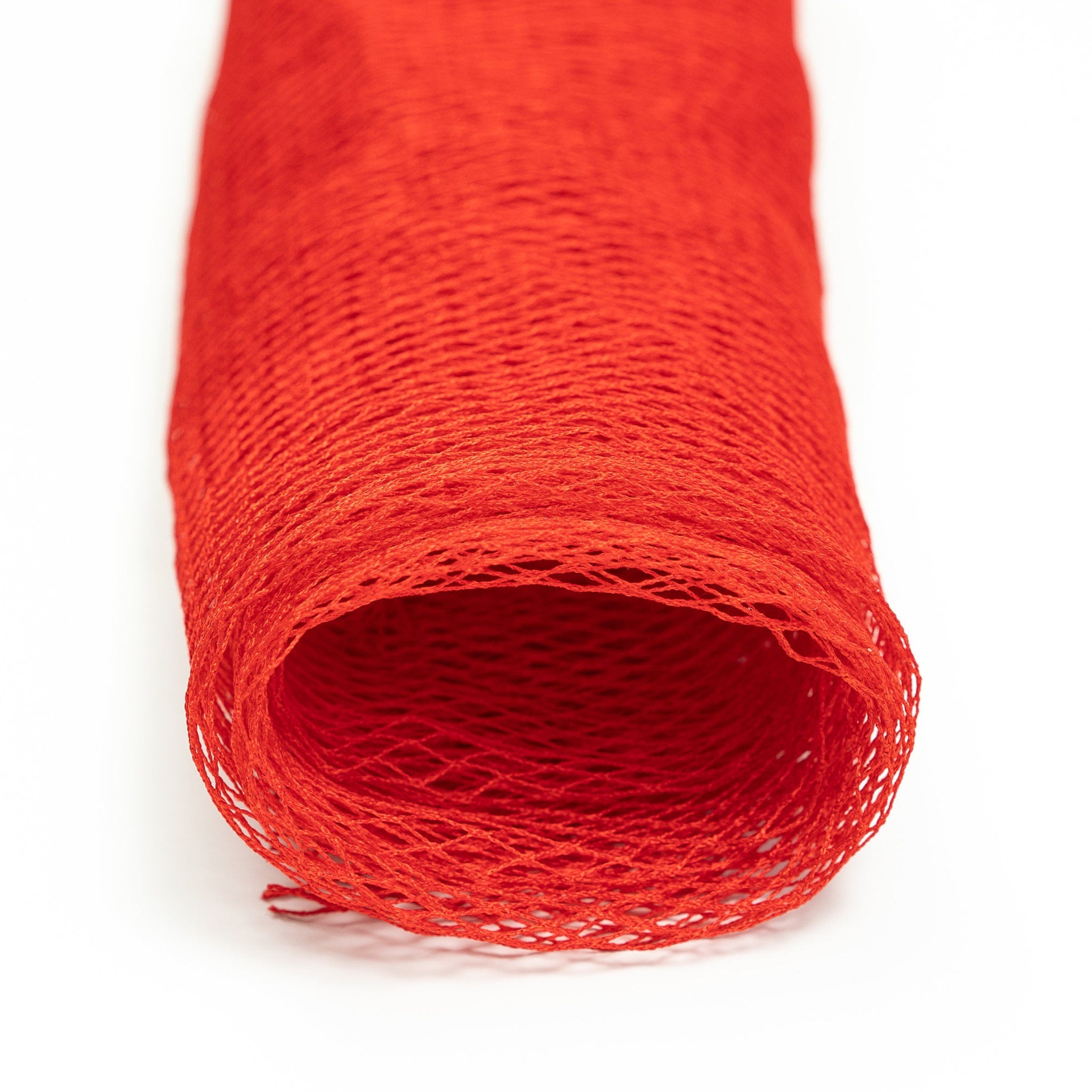 Red mesh fabric roll, open weave, cylindrical shape, close up view