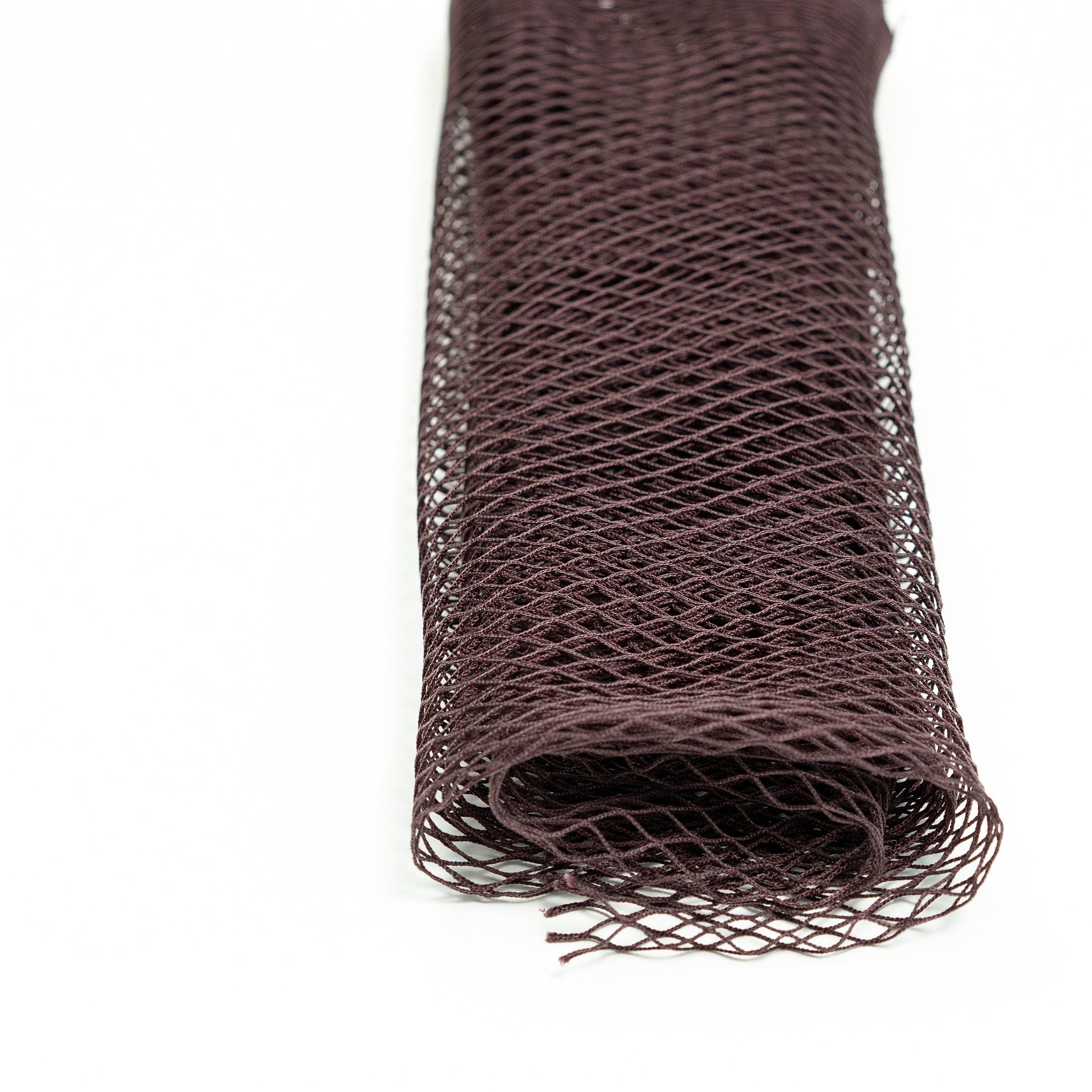 Netting material, dark brown, woven mesh, rolled up on white surface