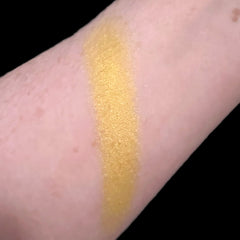Hand applying pearlescent peach eyeshadow with fingertip to eyelid for soft shimmer effect