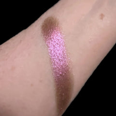 Close-up of a hand applying Fox Grape eyeshadow with a blending brush, showing smooth pigment build-up on eyelid.