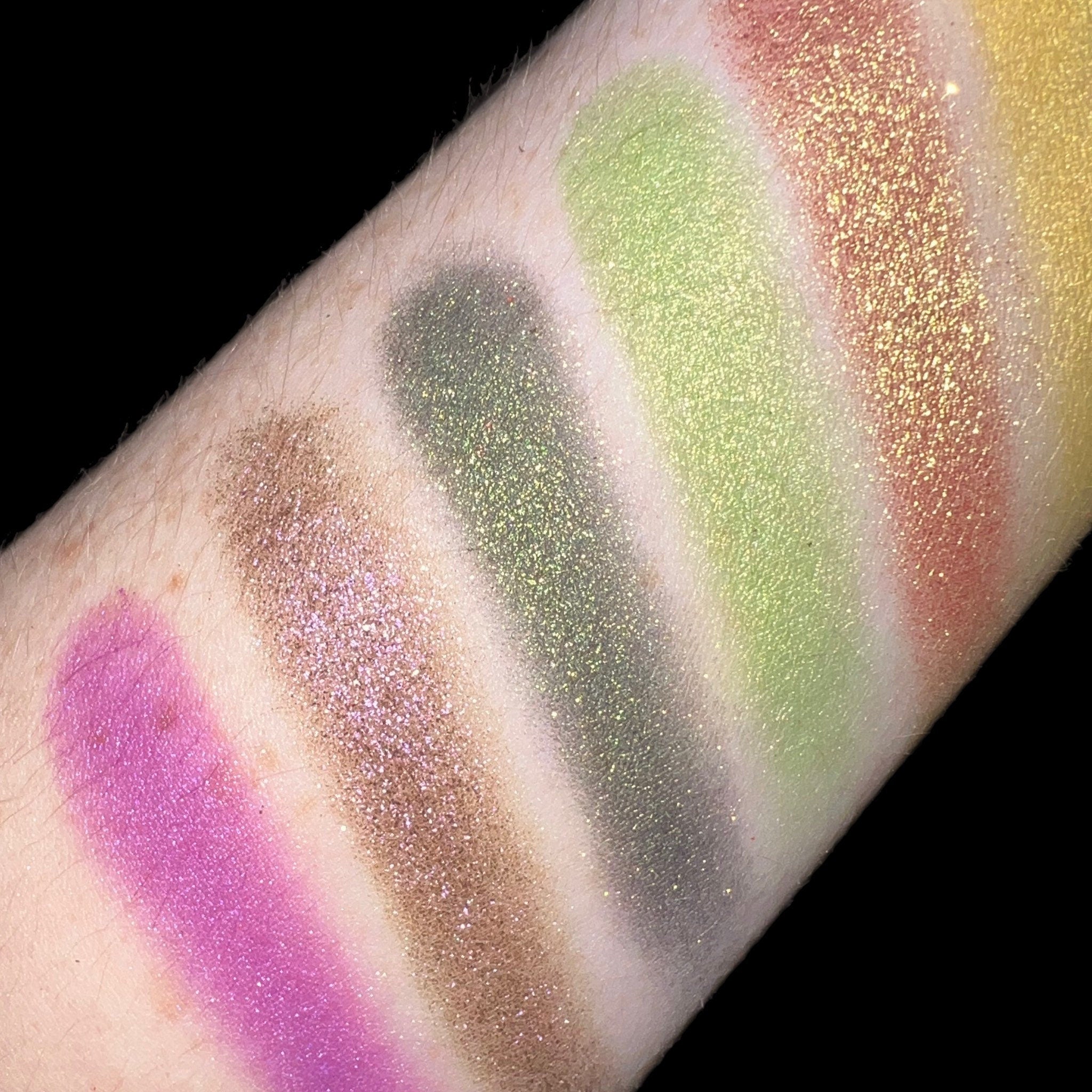 Close-up of duo chrome eyeshadow pan showing vibrant color shift from pink to gold shimmer