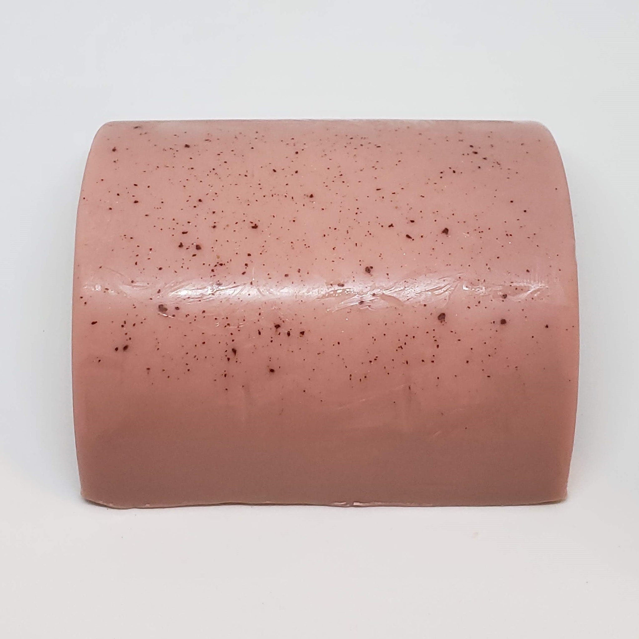 Soap bar, pink with dark speckles, rectangular shape on white background