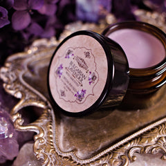 Lip balm jar with black lid, brown glass, and Eternaly Arcane label on ornate tray