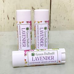 Lip balm tubes with white and floral pattern, Green Daffodil brand visible, three tubes displayed