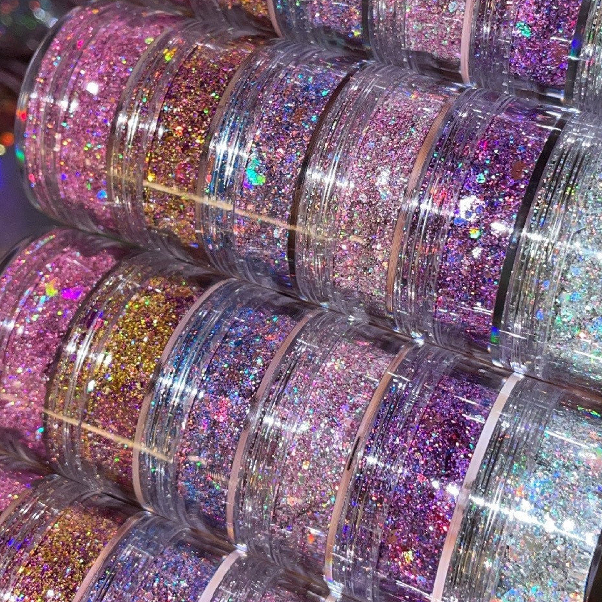 Close-up of iridescent chunky glitter eye shadow in a stack set, showing vibrant multicolor sparkle texture