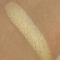 Close-up of light gold shimmer pressed pigment with intense metallic finish in round pan