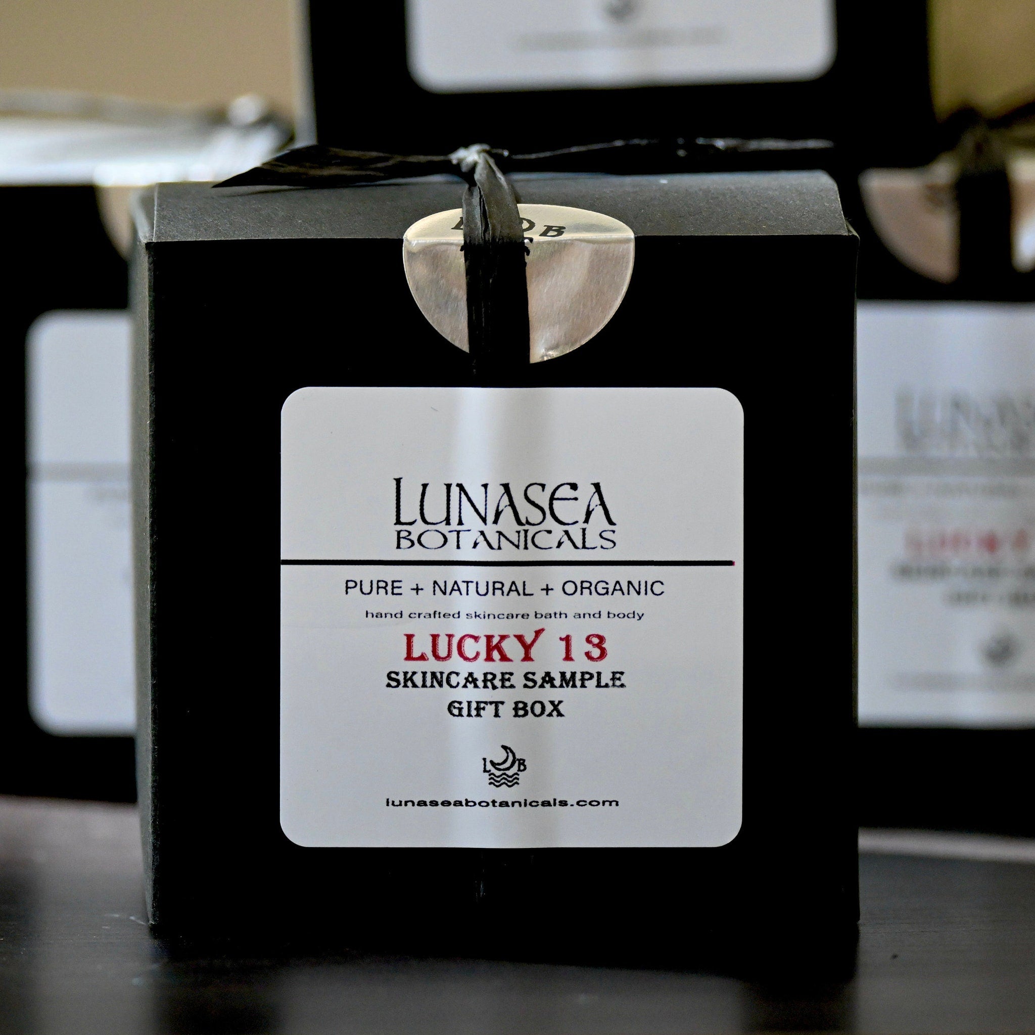 Skincare gift box with black box, white label, silver closure, LunaSea Botanicals branding