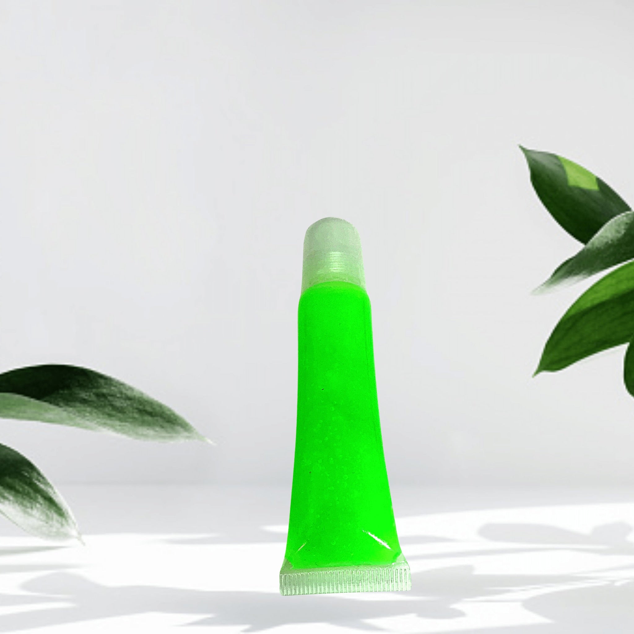 Lip gloss tube with green liquid, clear cap, and white tube base on white background