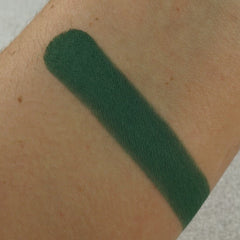 Close-up of matte evergreen eyeshadow pan showing smooth pressed powder texture and true-to-color pigment