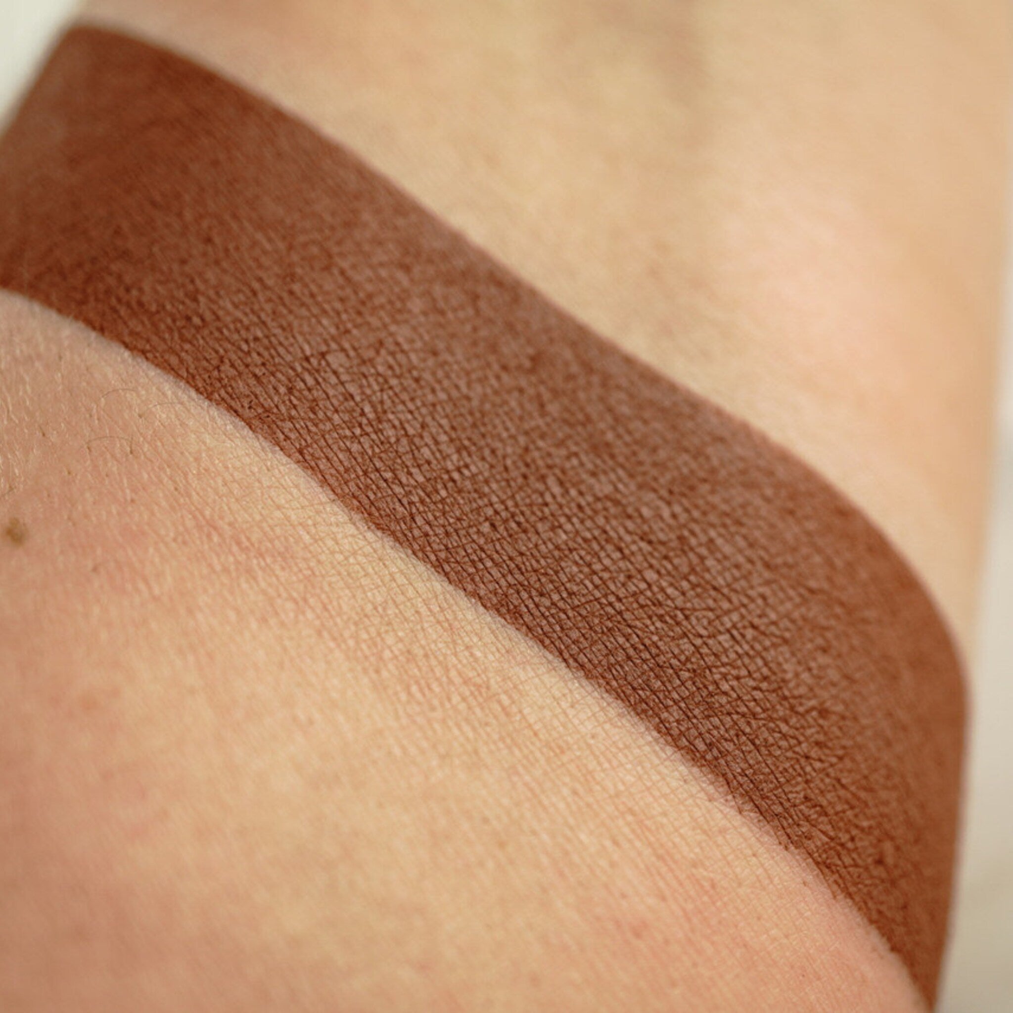 Close-up of matte pressed eyeshadow pan showing smooth pigment texture in a 26mm round compact