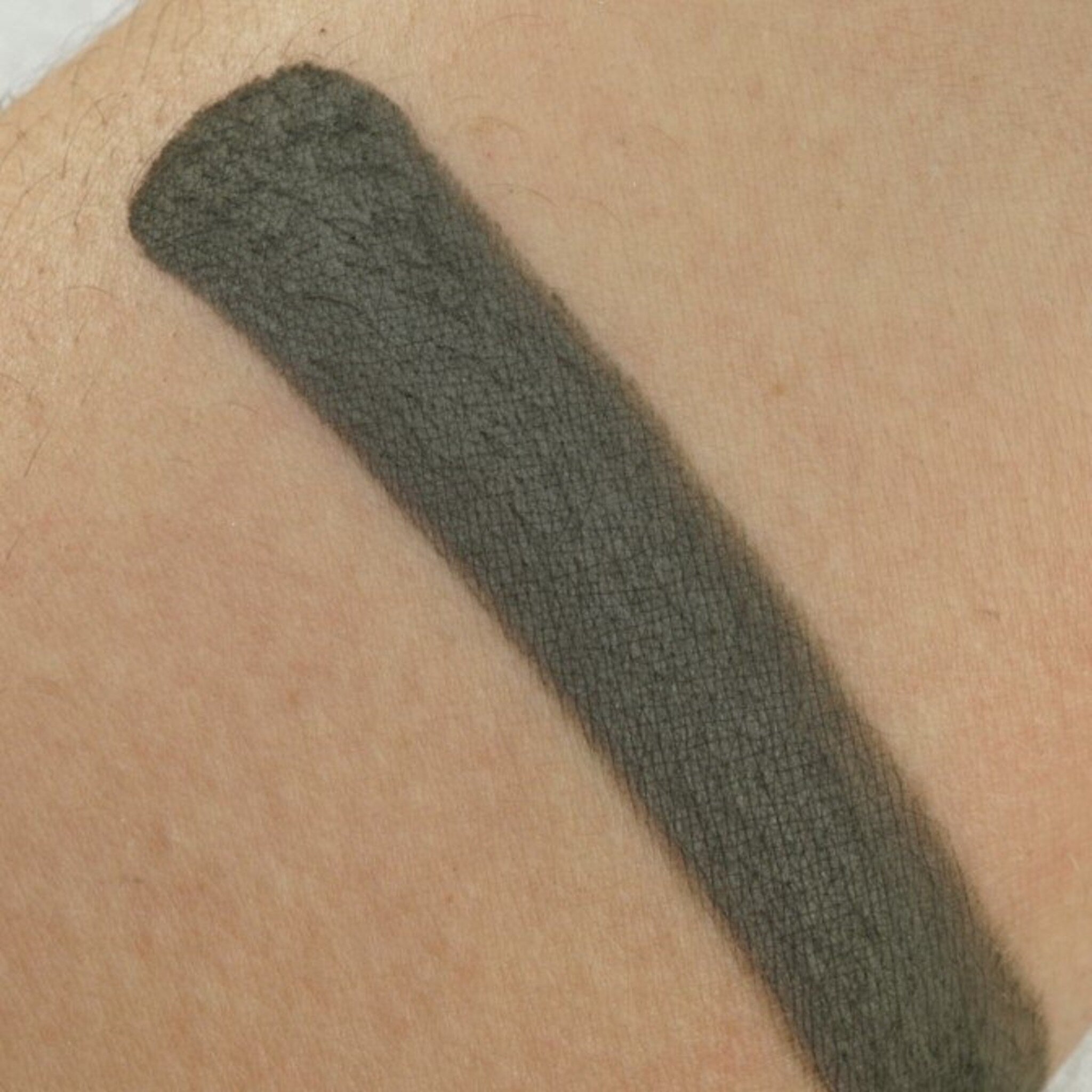 Close-up of matte moss green eyeshadow pan showing smooth pressed powder texture and true-to-color pigment