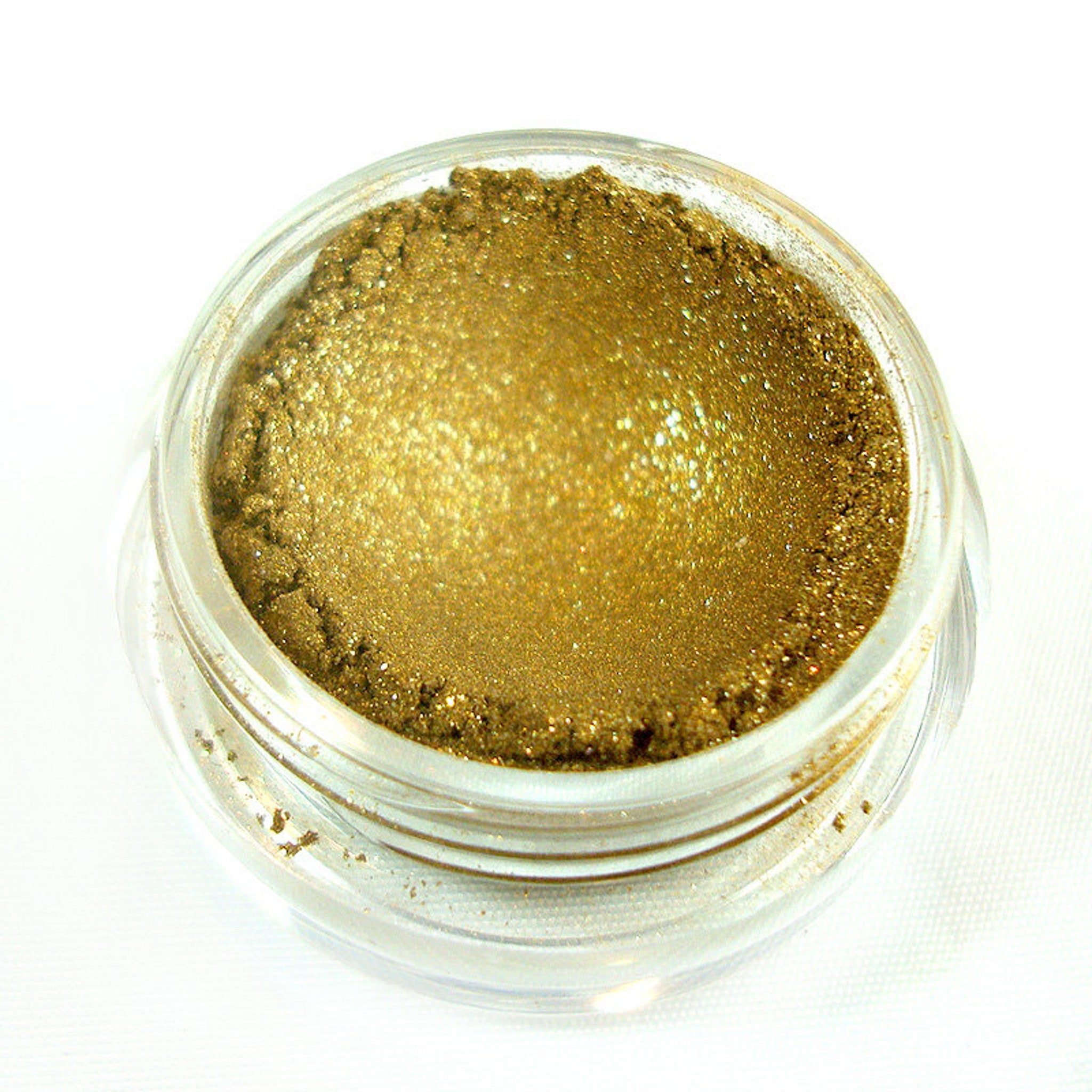 Close-up of mineral eye shadow pan showing finely milled shimmering taupe powder with smooth texture