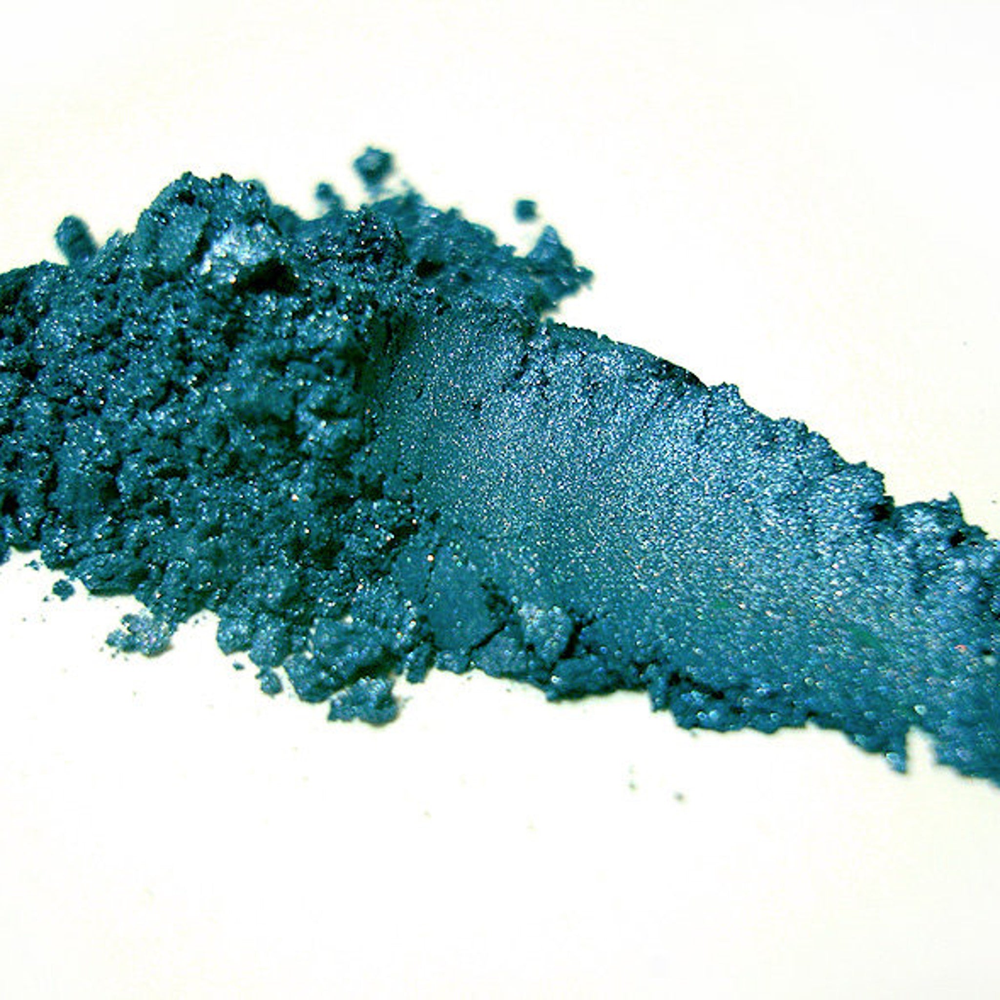 Close-up of Ligeia mineral eye shadow pot showing finely milled powder in a shimmering bronze shade