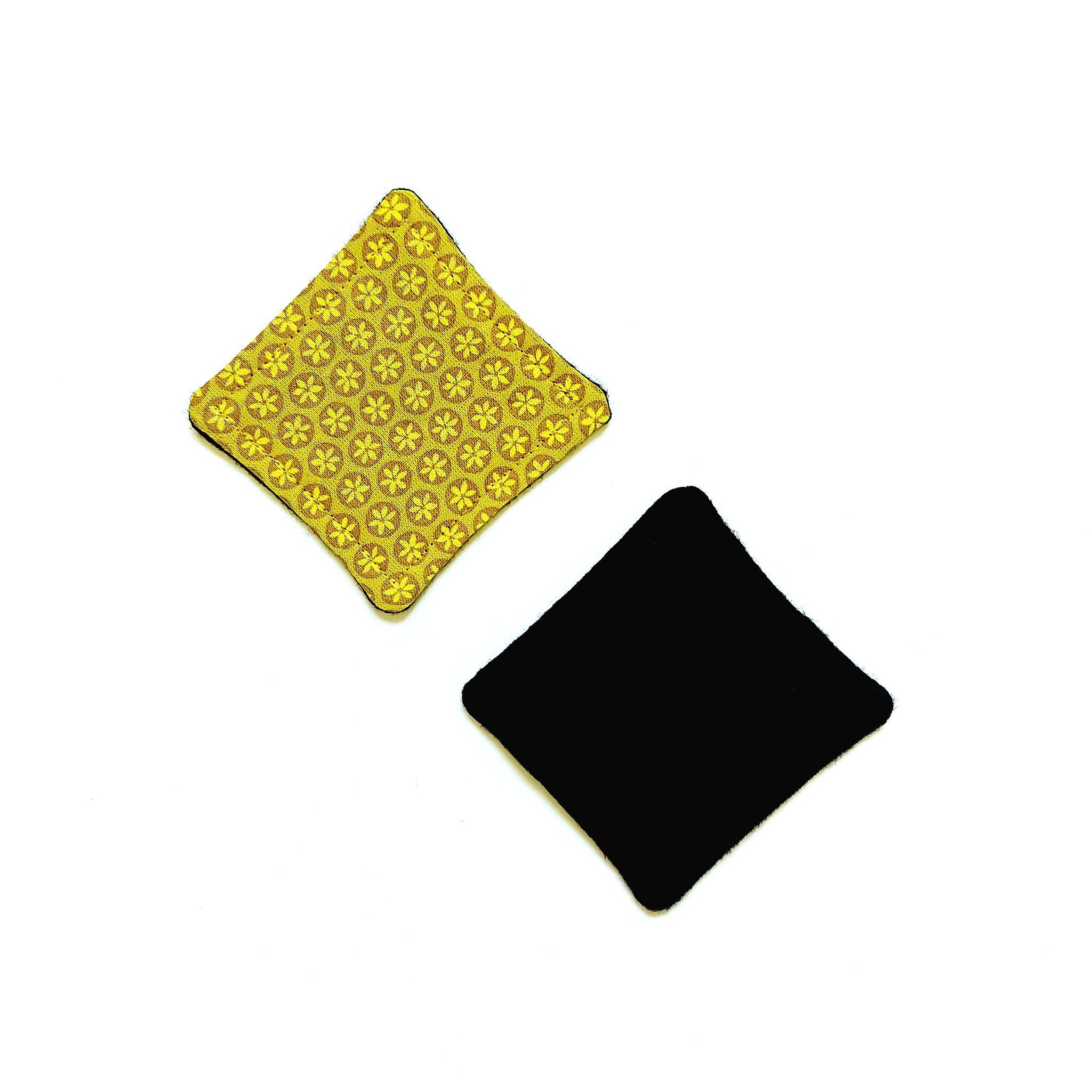 Diamond-shaped coaster with yellow floral pattern and solid black, soft material