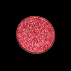 Side view of MAC Fruit Moon eyeshadow in a round black compact, showcasing peachy-pink shimmer texture.