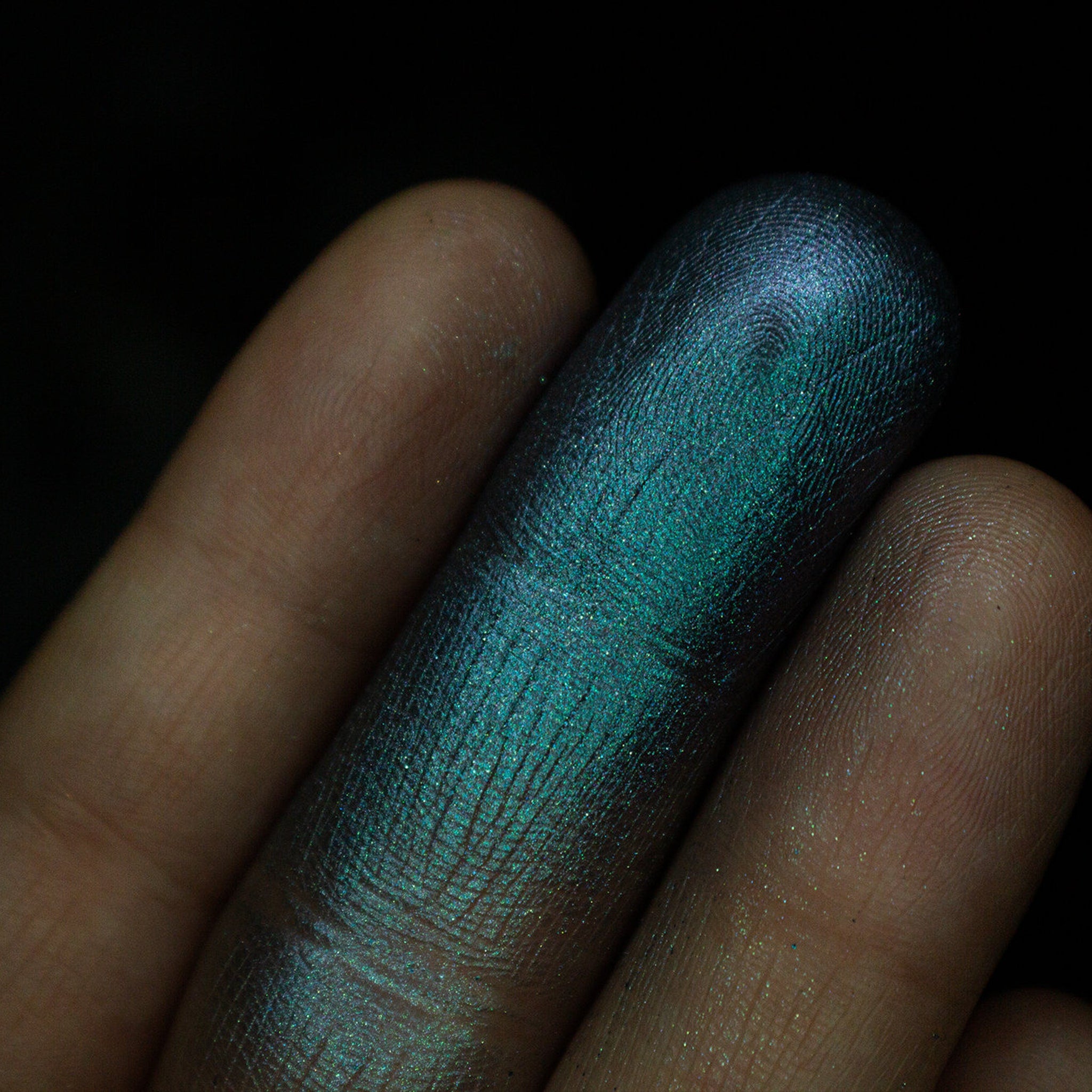 Open compact showing grungy blue to purple duochrome eyeshadow with shimmer finish