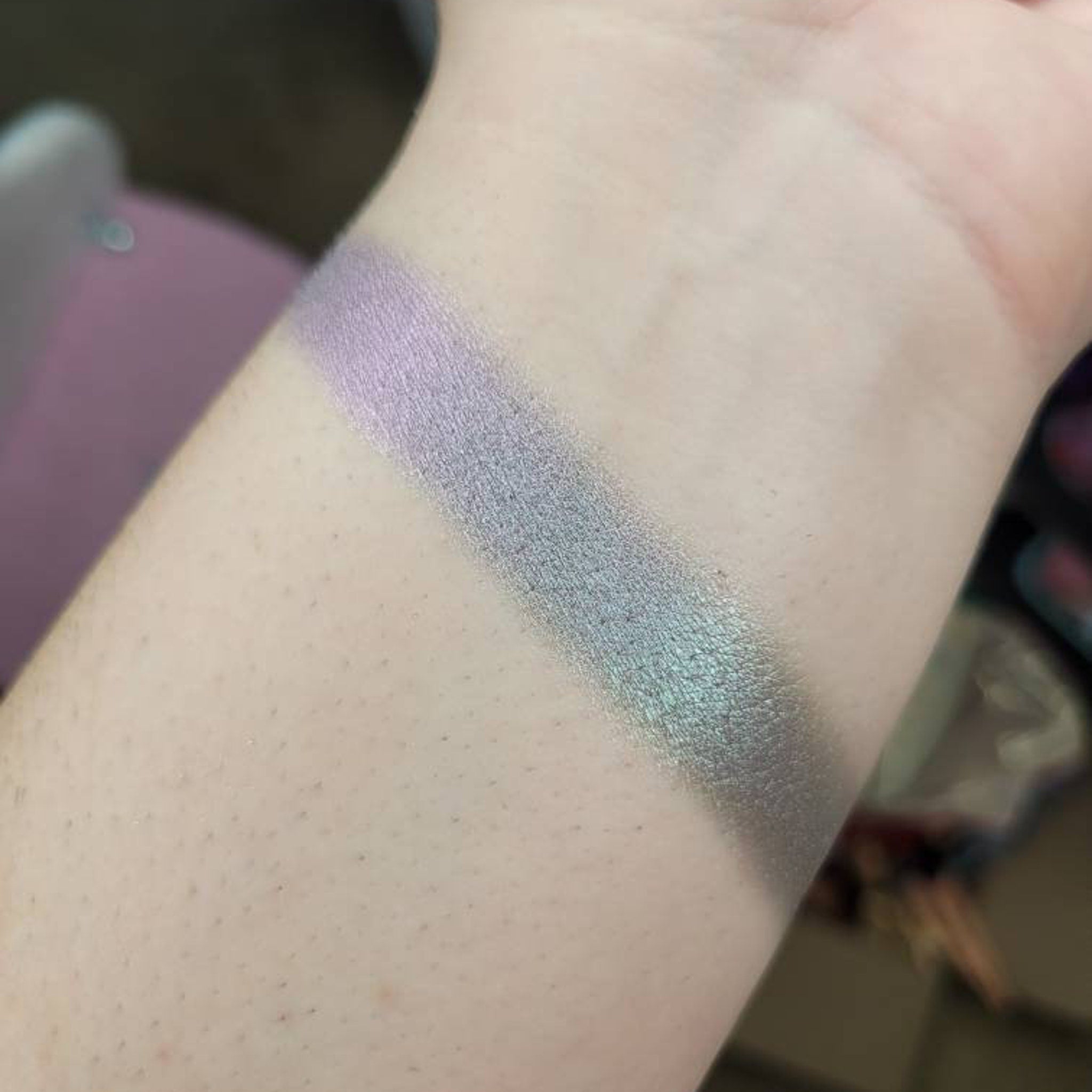 Eyeshadow swatches, iridescent shimmer, lilac and teal shades, applied on skin
