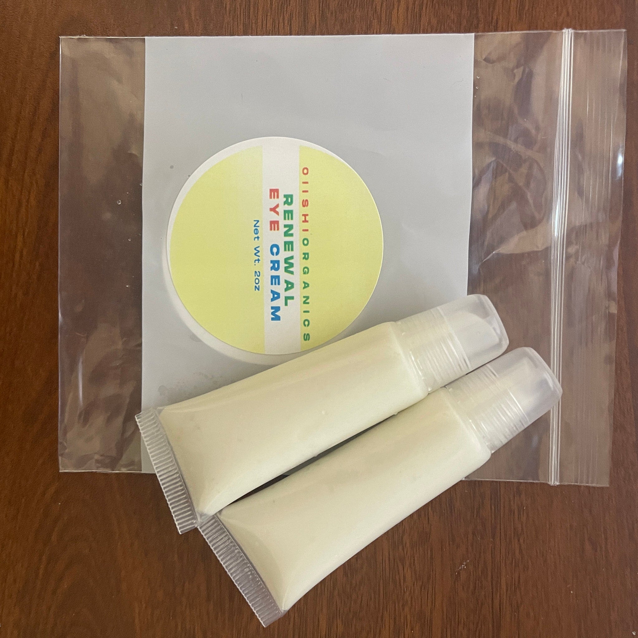 Eye cream set with yellow and white packaging, clear plastic bag, and OIIISHIORGANICS text visible