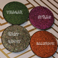 Side angle of multichrome grey eyeshadow pan showcasing intense shimmer and color shift to green and blue hues