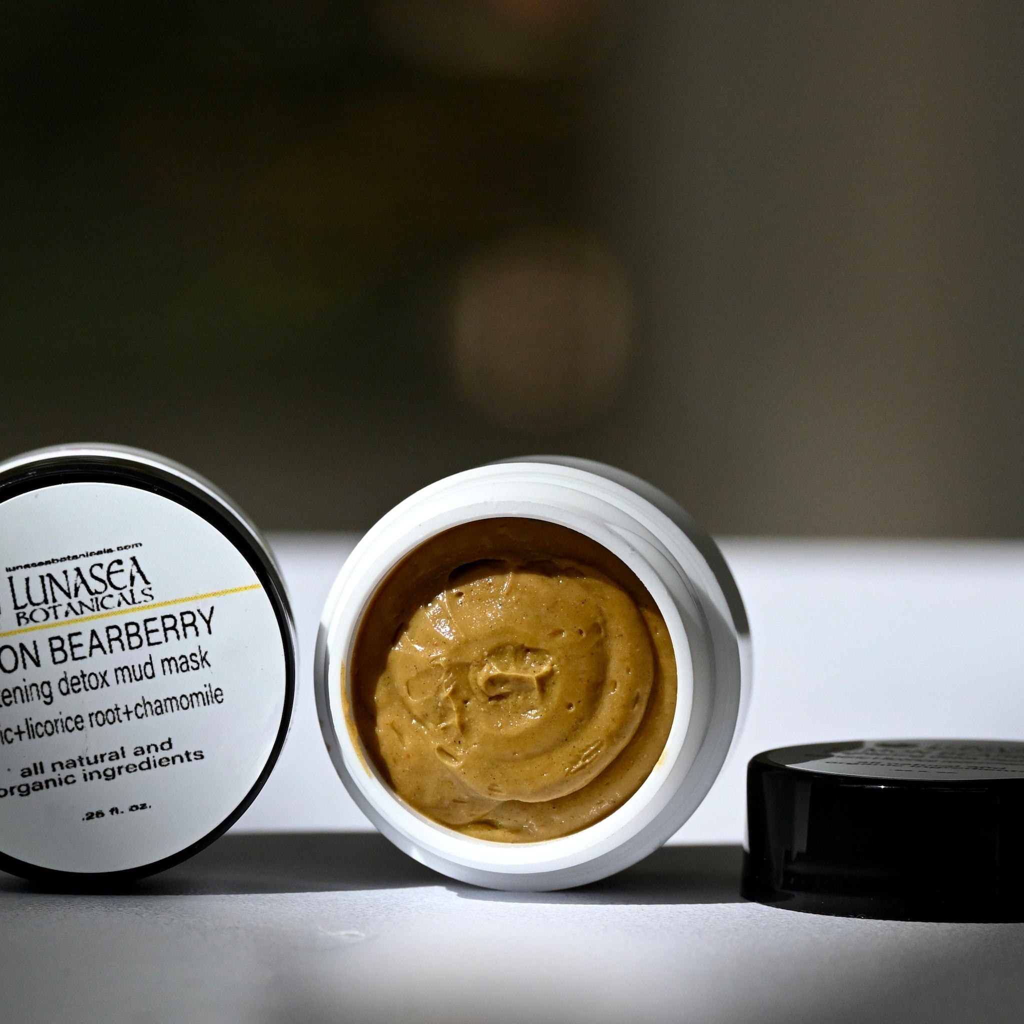 Mud mask with light brown color, white container, and black lid, Lunasea Botanicals label visible