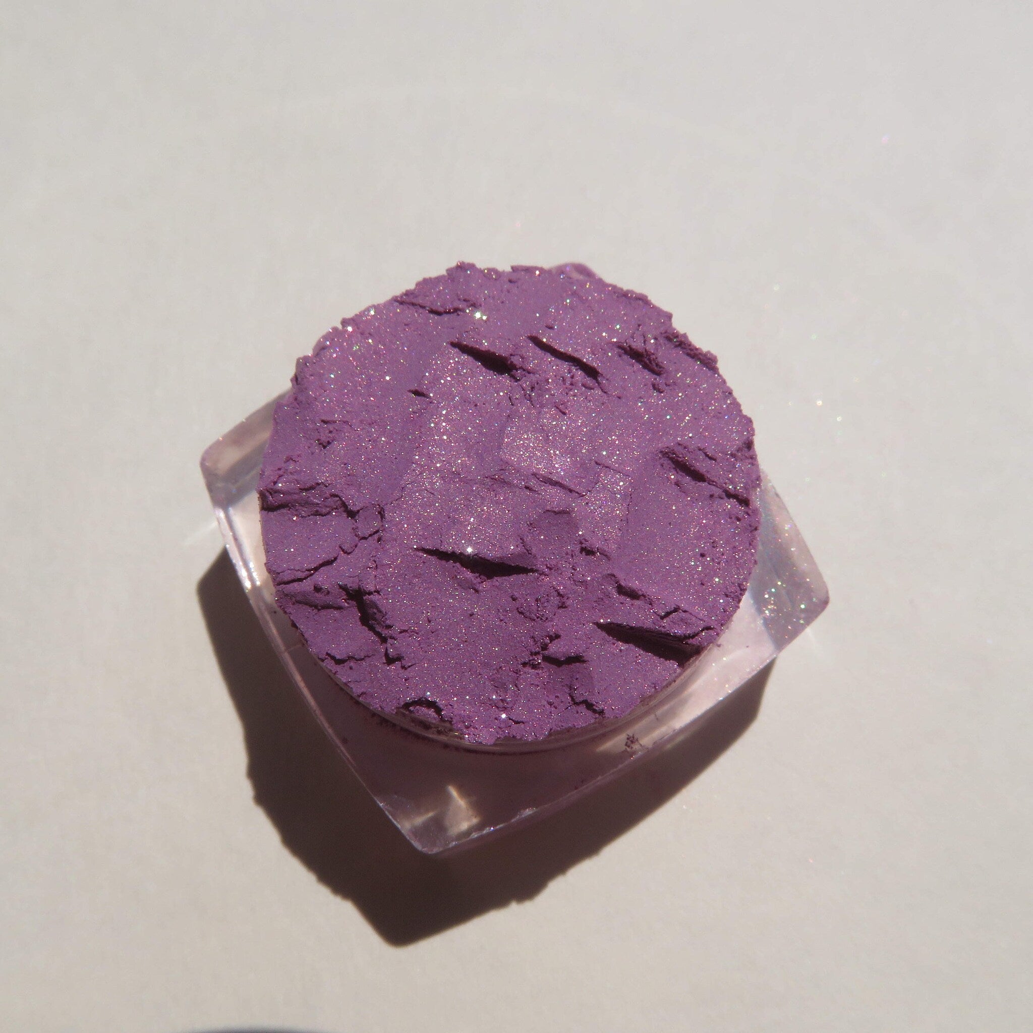 Hand applying Jessica Pure Mineral Eyeshadow in purple shimmer as loose pigment with a brush