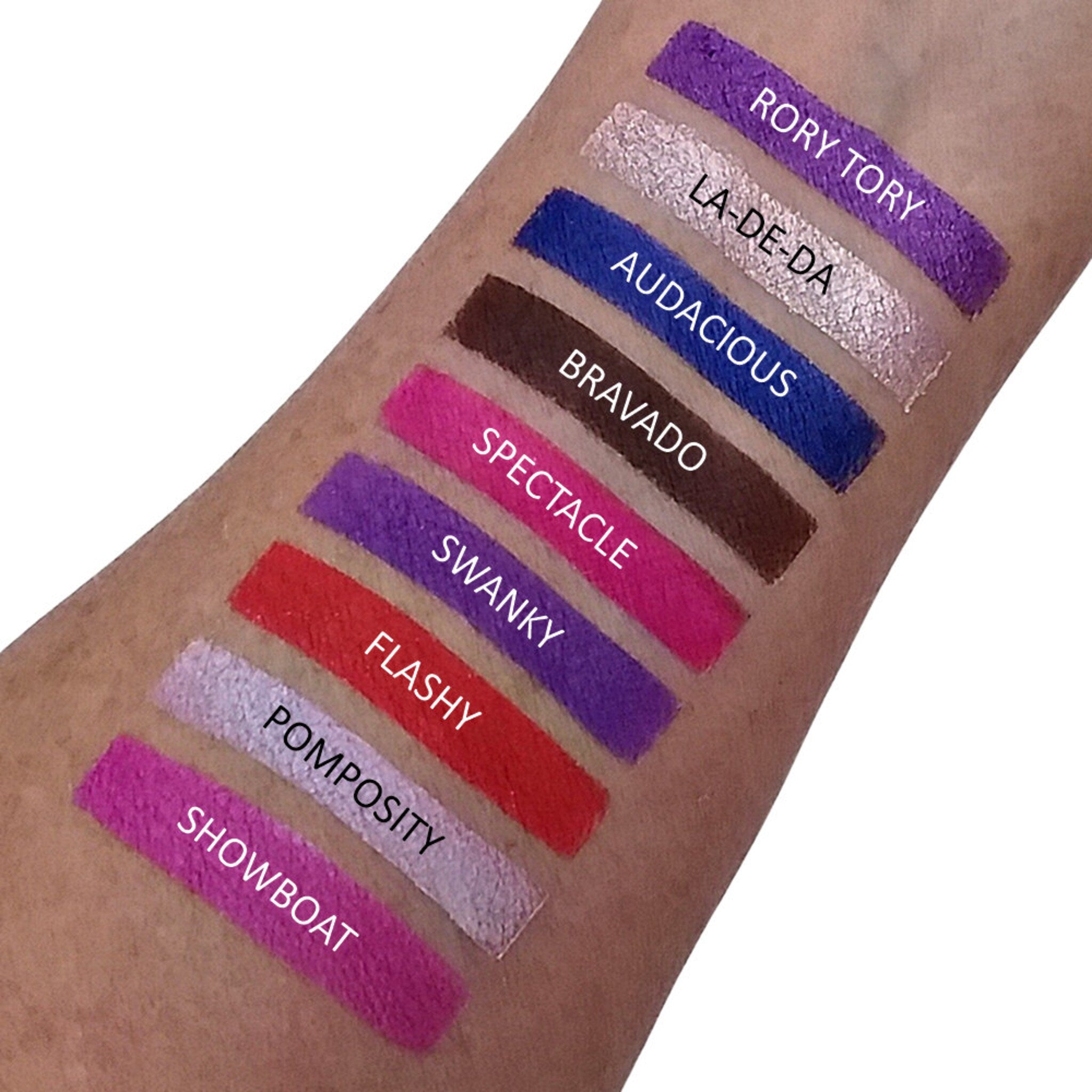 Close-up of fingertips applying vibrant teal eyeshadow from palette to eyelid