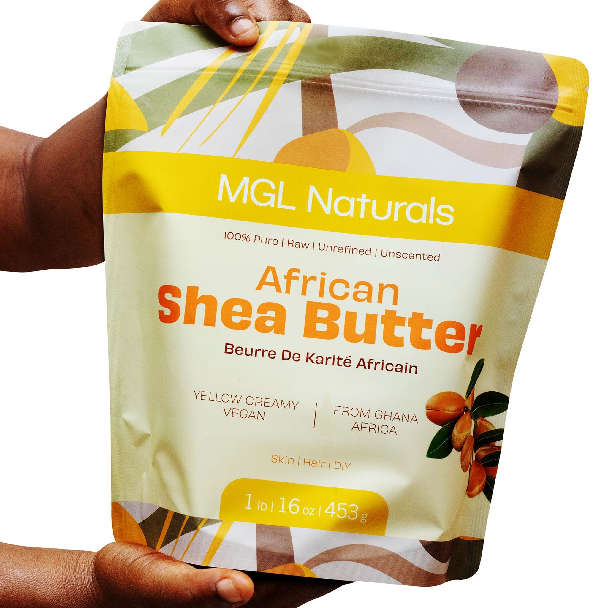 African Shea Butter bag with yellow and cream colors, MGL Naturals branding, held by hands.