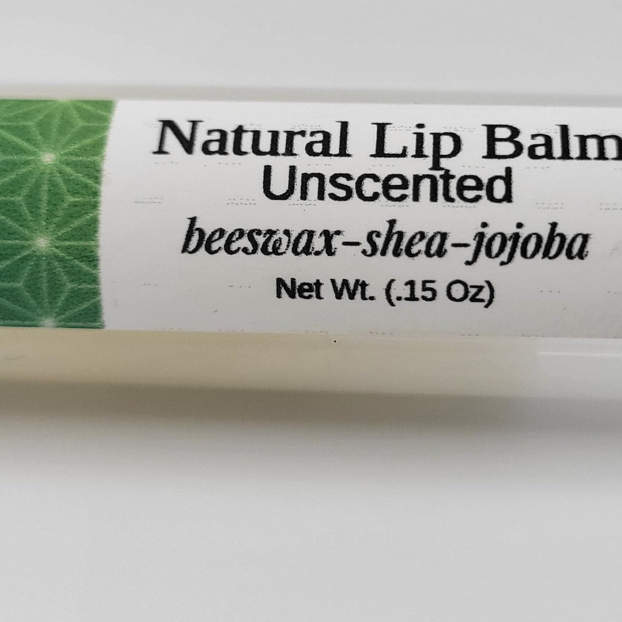 Lip balm tube with white and green label, black text, and natural ingredients listed