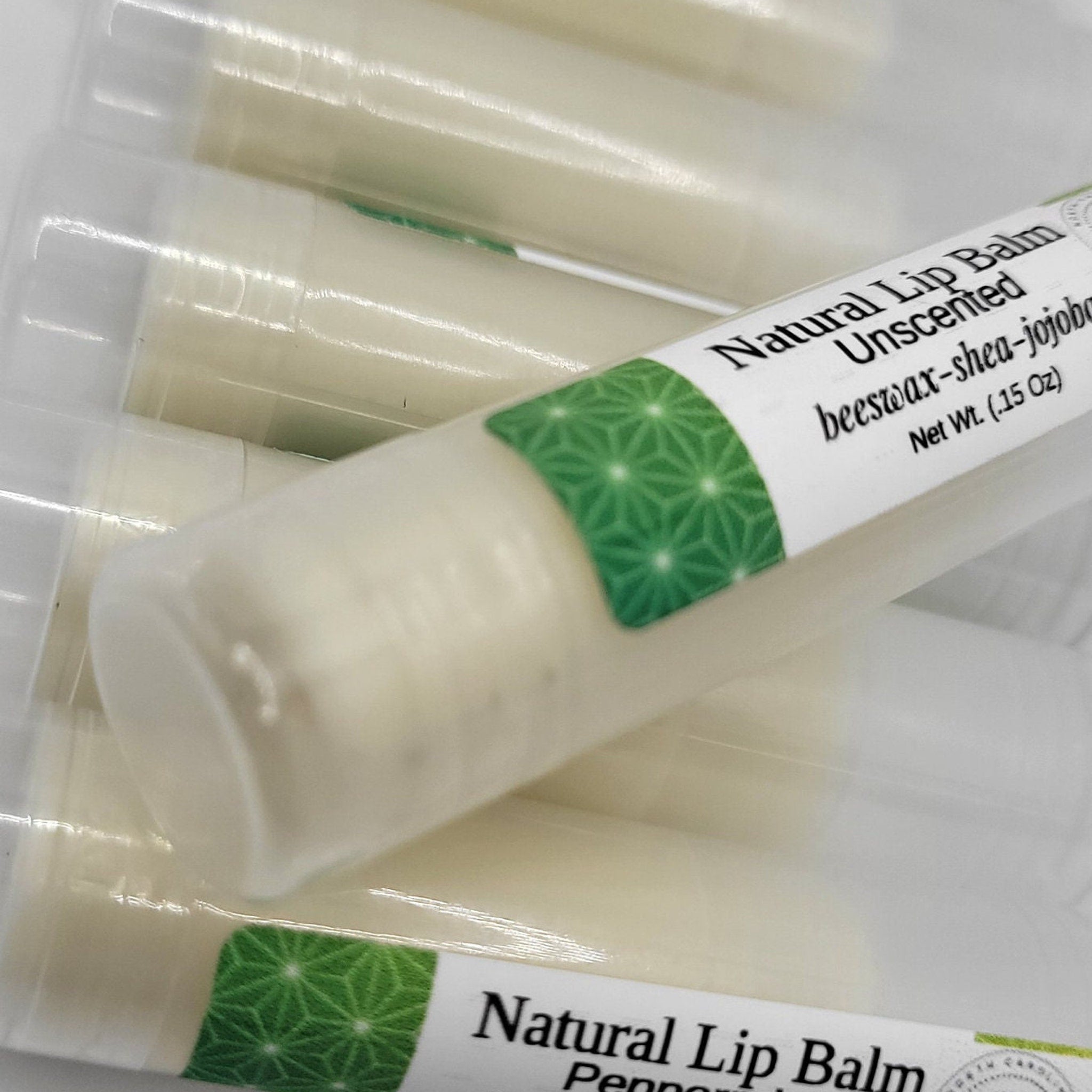 Lip balm tubes with white and green labels, clear plastic packaging, and visible text