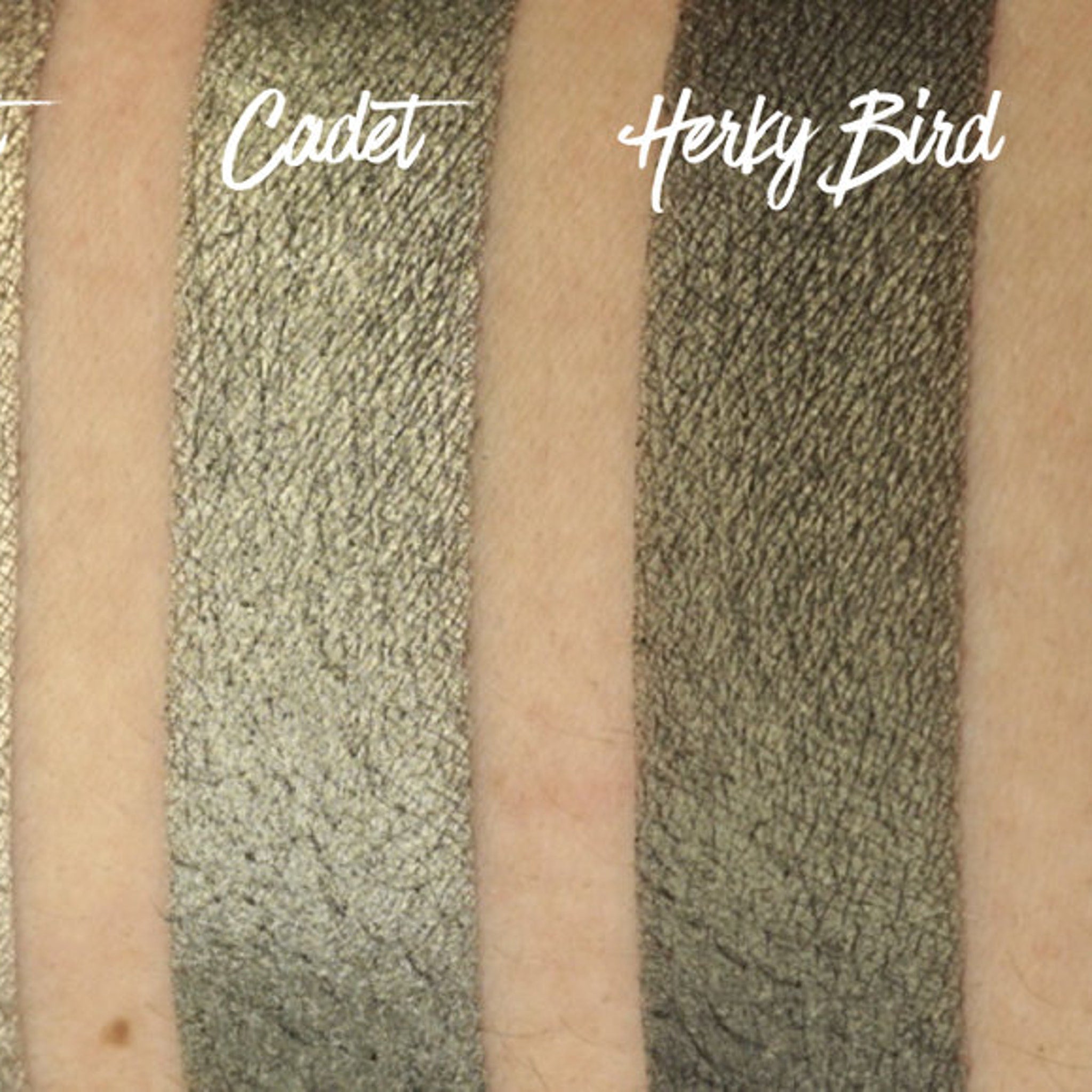 Hand applying army green shimmer eyeshadow with fingertip, showcasing pigmented payoff on skin