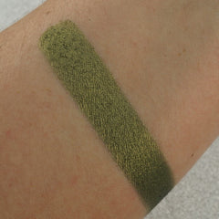 Close-up of pearlescent green eyeshadow pan with shimmer finish and smooth pressed pigment texture