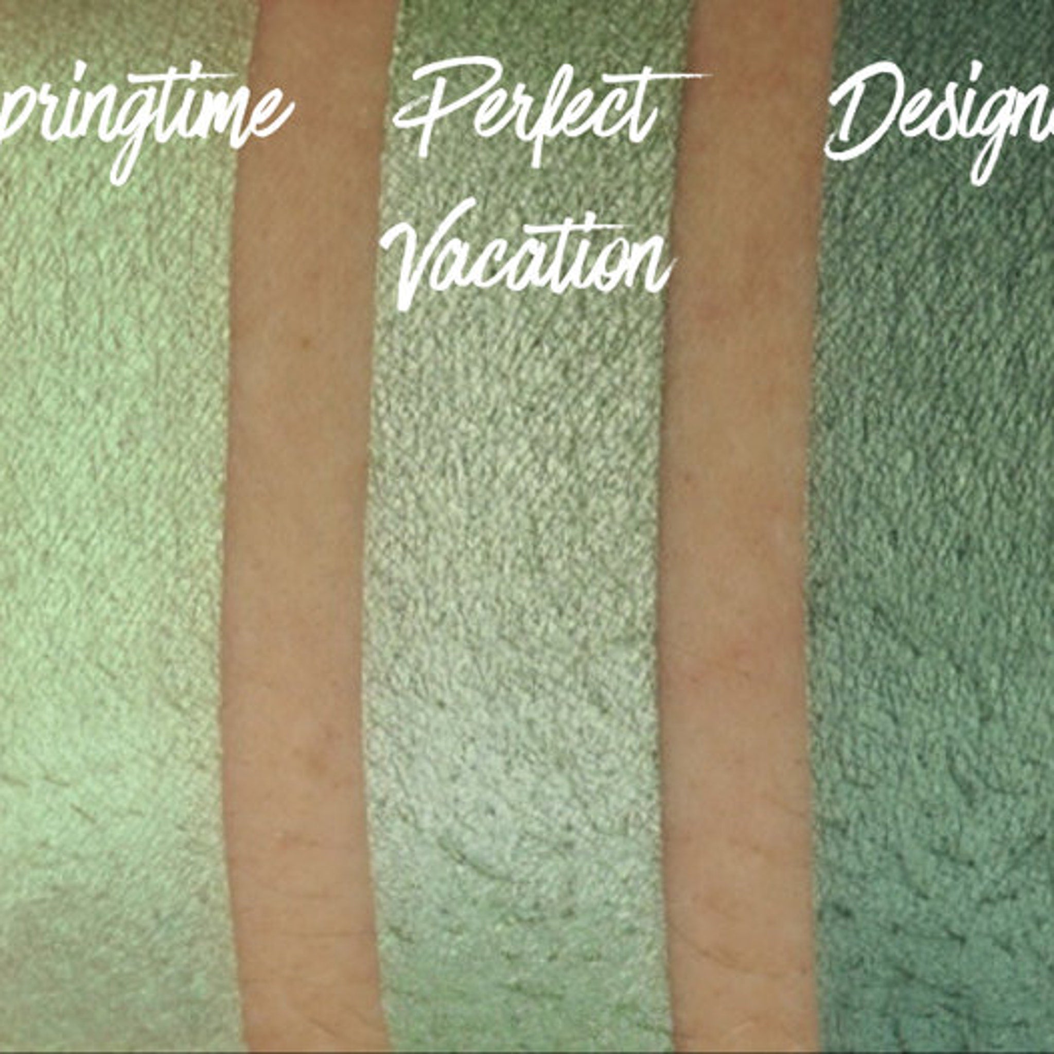 Hand applying shimmering green and blue chrome eye shadow duo with fingertip for bold metallic look