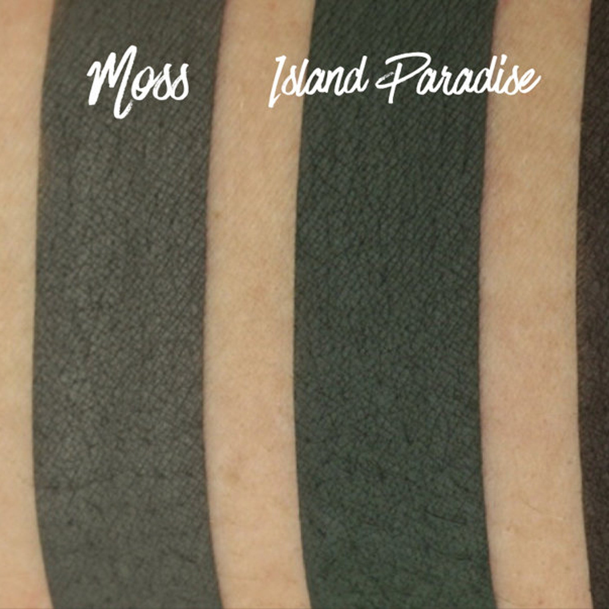 Hand applying matte moss green eyeshadow with a brush onto eyelid, showing pigmented color payoff