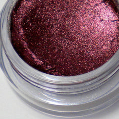 Close-up of two mineral vegan eyeshadow shades in round 5g jars with matte black lids