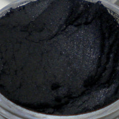 Black powder with textured surface and visible shimmer in container