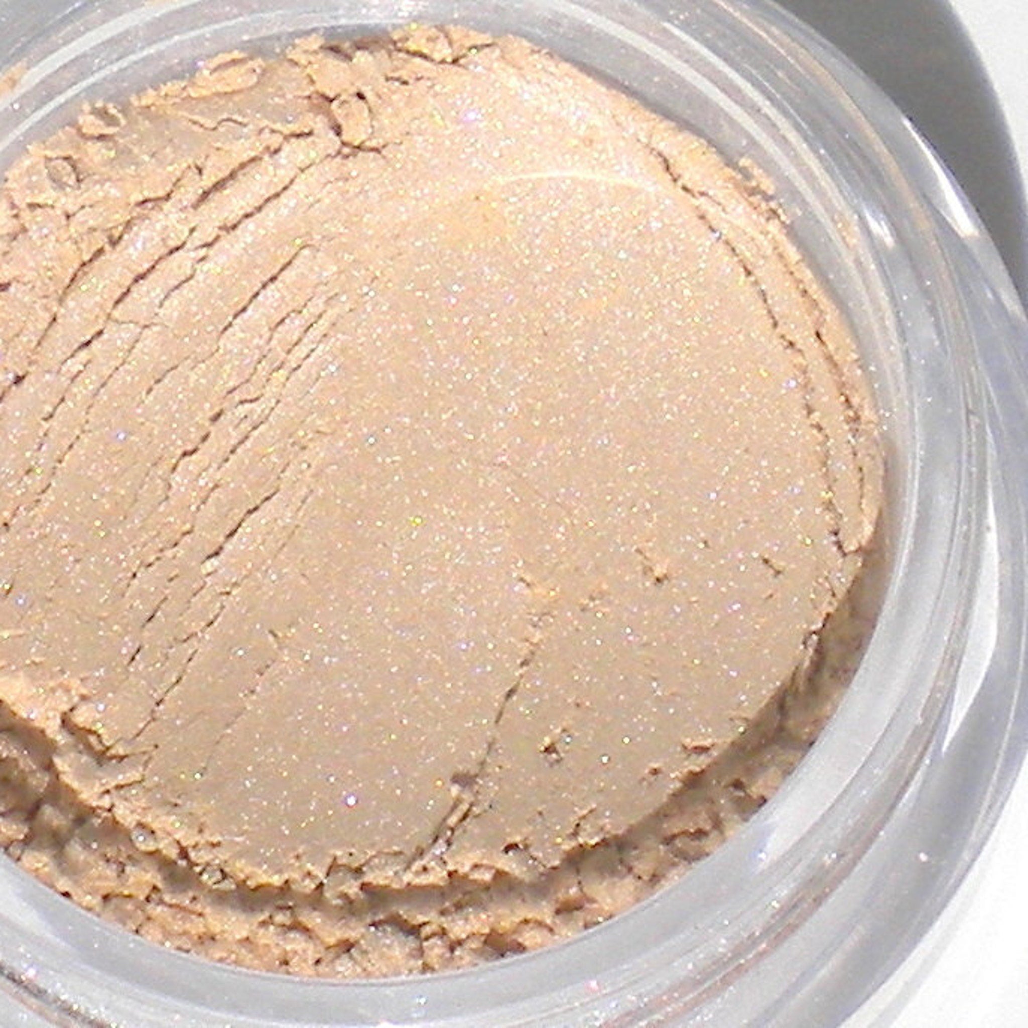 Side view of two 5g mineral eyeshadow jars showing matte taupe and shimmery champagne shades in round containers