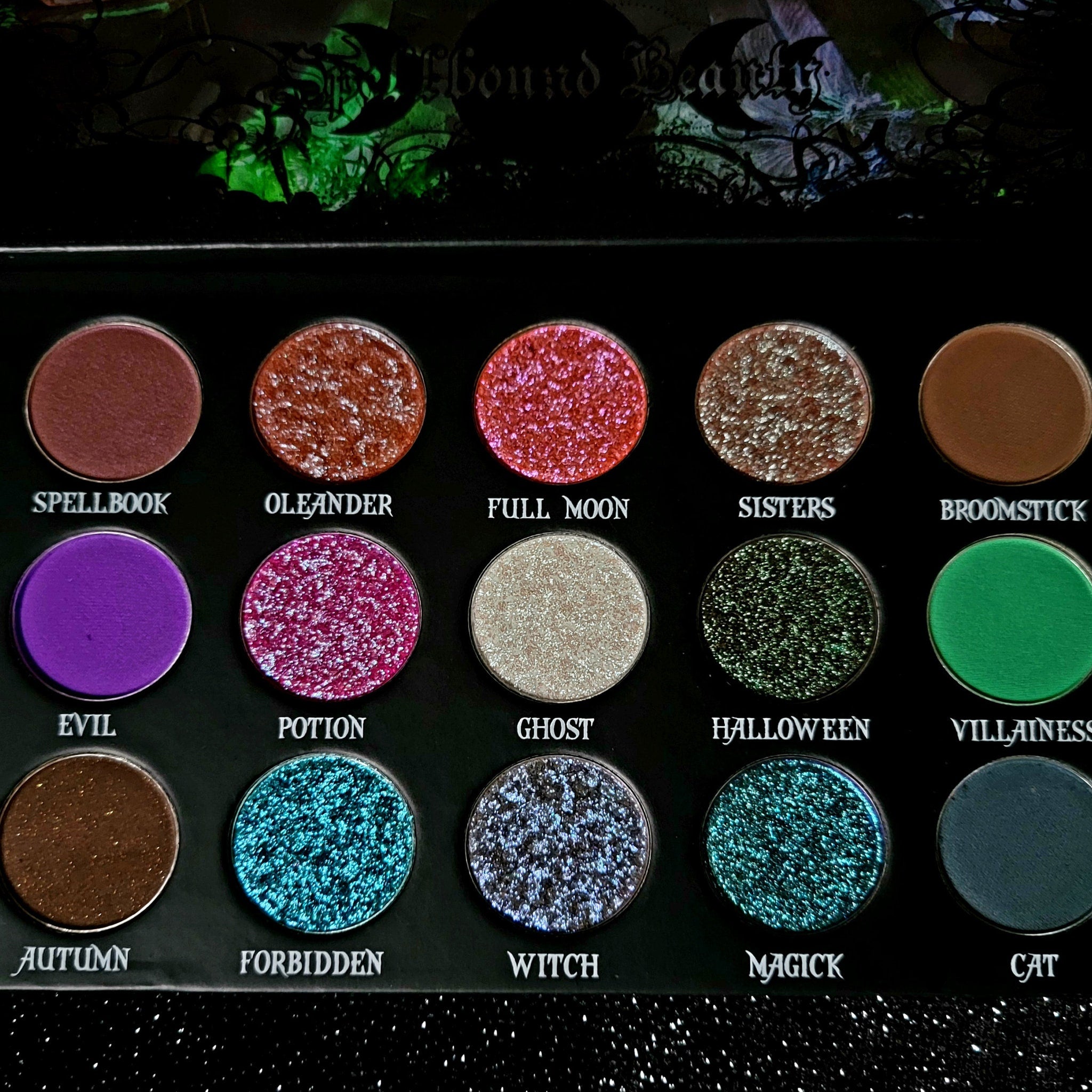 Eyeshadow palette with various colors, including glittery red, green, and blue shades, with text "Hound Beauty" visible