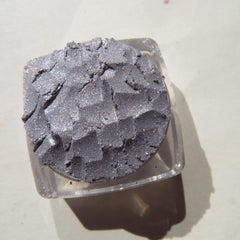 Hand applying shimmery silver chrome loose pigment eyeshadow with fingertip for bold metallic look