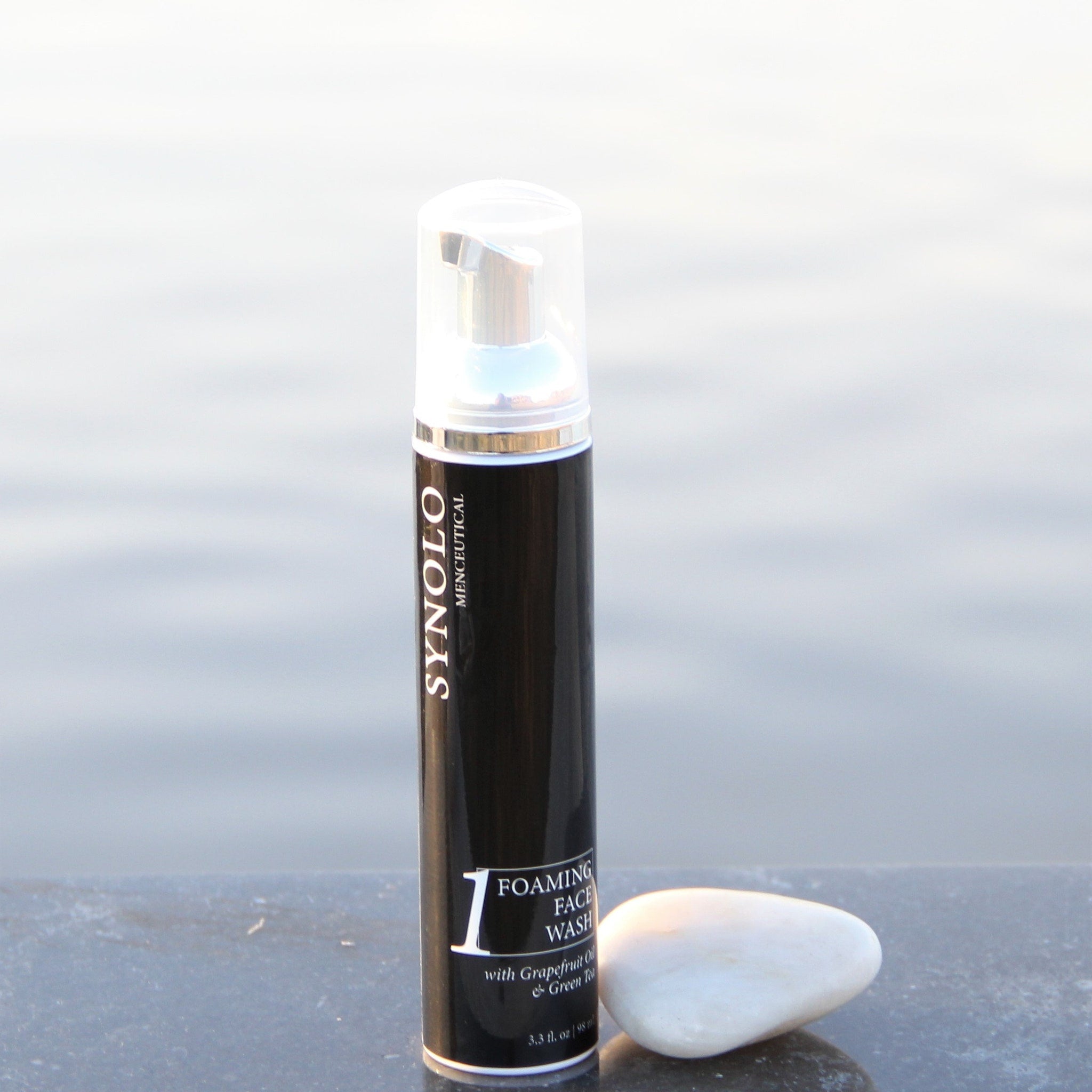 Foaming face wash black bottle with silver accents and clear pump, SYNOLO brand displayed