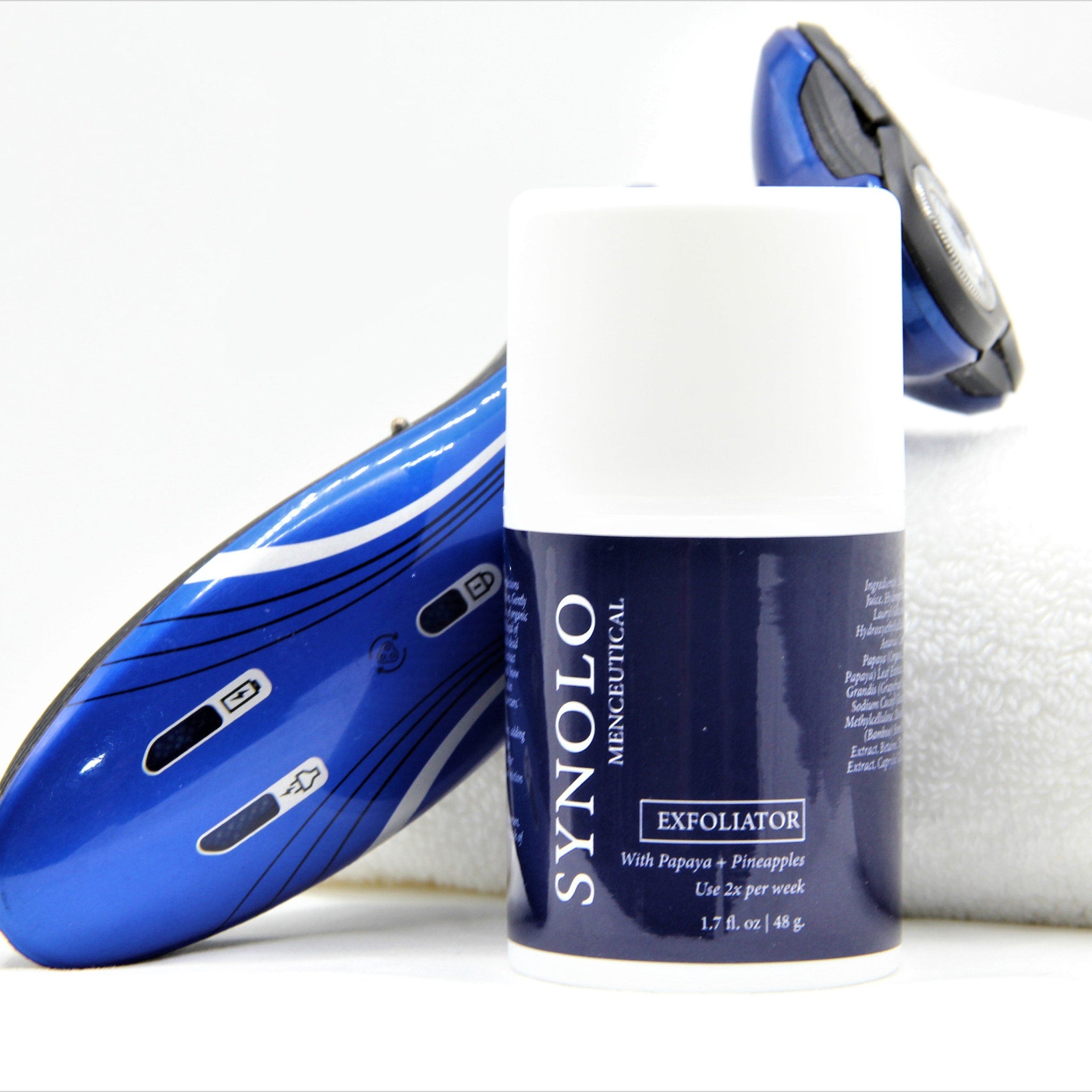 Exfoliator product with blue and white branding, next to a blue electric razor, on a white background.