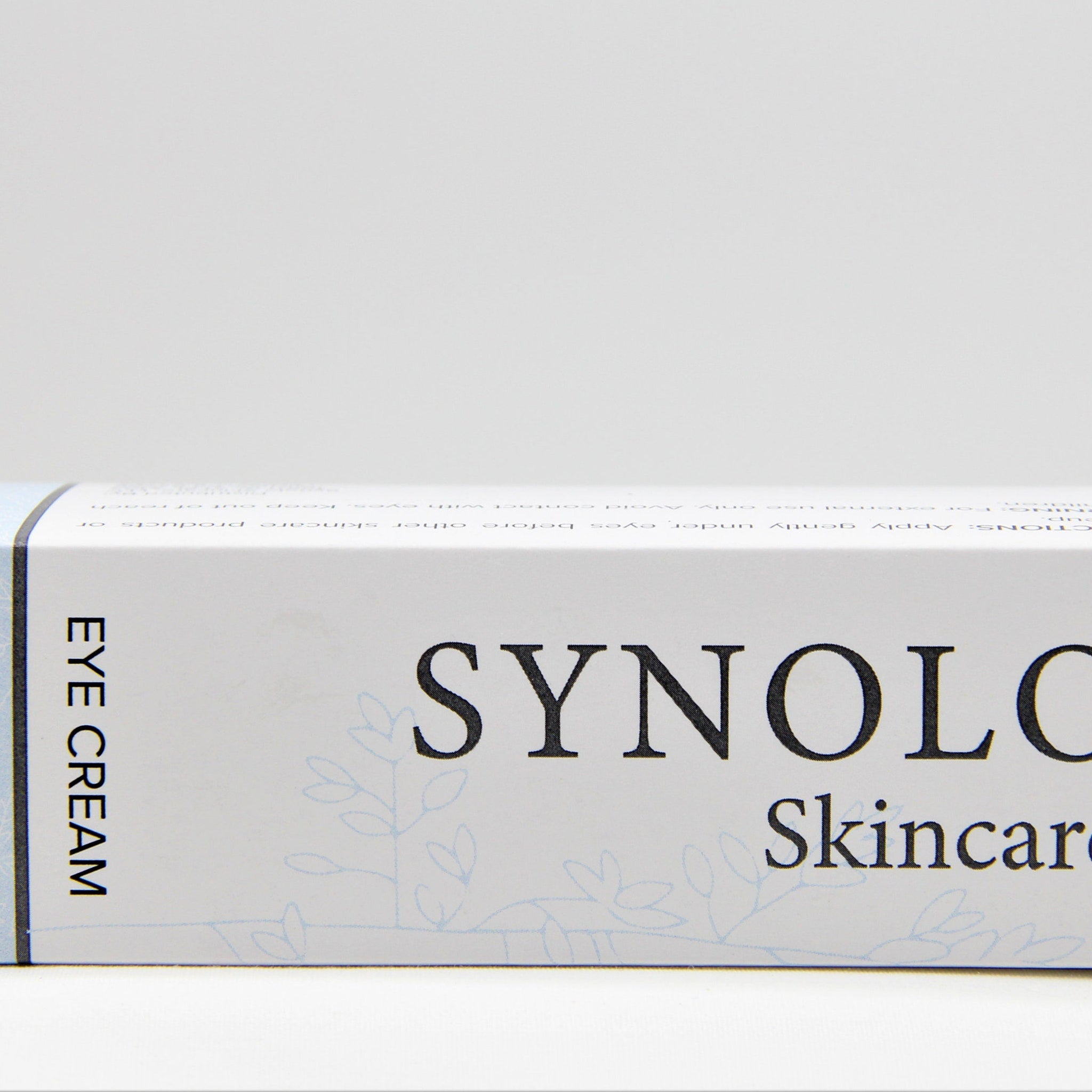 Eye cream box with white background, black text, and Synolo Skincare branding