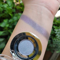 Eyeshadow swatch, lavender shimmer, round compact, applied on wrist for color test