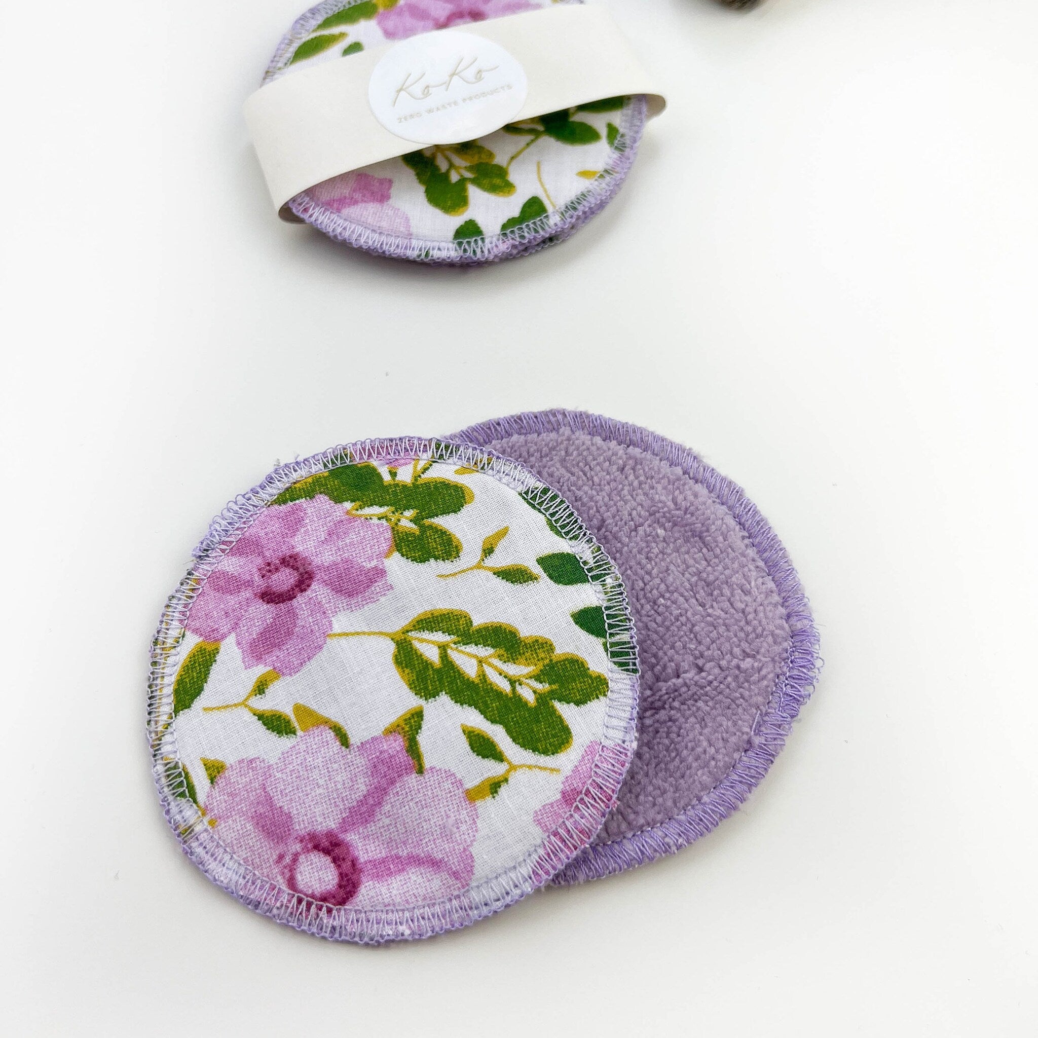 Reusable facial rounds with floral print, purple trim, and soft material, by Koko